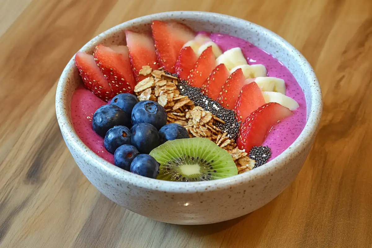 Colorful pitaya bowl with fresh fruit, granola, and chia seeds.